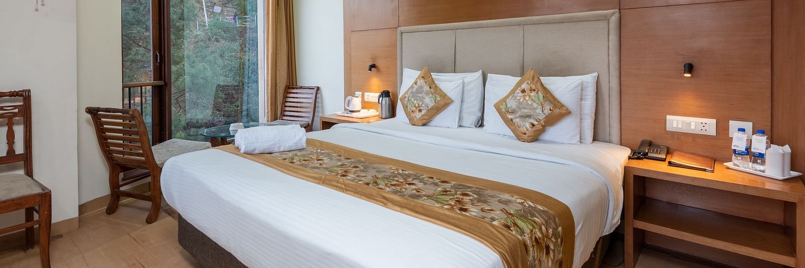 A bedroom featuring a king size bed and a table with tea & coffee make next to the bed at DLS Hotels The Rock Castle.